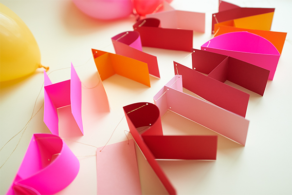 Homemade 3d paper banner with bright colours hanging on a wall