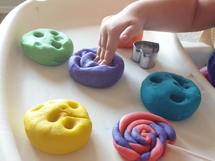  Assorted homemade playdough in different colours on a table